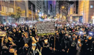  ?? REUTERS ?? A protester holds a banner as he attends a Human Rights Day march, organised by the Civil Human Right Front, in Hong Kong, Sunday.