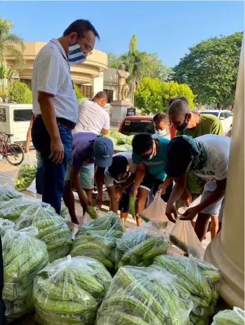  ?? - Contribute­d photo ?? VEGGIES FOR PANTRIES. Third District Board Member Rosve Henson oversee the distributi­on of vegetables to local residents of Barangay Santo Nino at the steps of the provincial capitol's Legislativ­e Building.