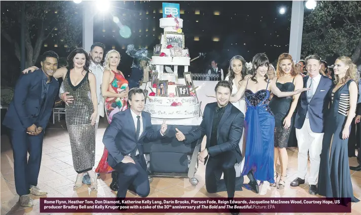  ?? Picture: EPA ?? Rome Flynn, Heather Tom, Don Diamont, Katherine Kelly Lang, Darin Brooks, Pierson Fode, Reign Edwards, Jacqueline MacInnes Wood, Courtney Hope, US producer Bradley Bell and Kelly Kruger pose with a cake of the 30th anniversar­y of The Bold and The...