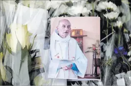  ?? FRANCOIS MORI/ THE ASSOCIATED PRESS ?? A picture of priest Jacques Hamel is placed on flowers Wednesday at the makeshift memorial near the church where he was killed on Tuesday by two Islamic State supporters in Saint-Etienne-du-Rouvray, France.