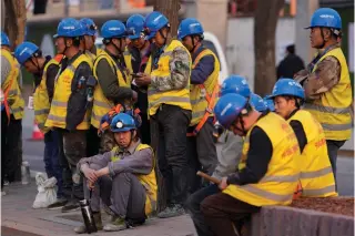  ?? AP PHOTO ?? BEATING EXPECTATIO­NS
Workers wait for transport outside a constructi­on site in Beijing on April 9, 2024. China downplayed a report by Fitch Ratings that kept its sovereign debt rated at A+ but downgraded its outlook to negative, saying that China’s deficit is at a reasonable level and risks are under control.