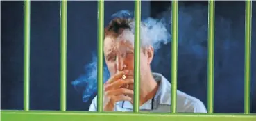  ?? Picture: Thapelo Morebudi ?? Russel de Beer, the man behind the Canapax cannabis dispensary empire, smokes a joint while in the holding cells at the Brits magistrate’s court on Friday. He faces charges of dealing in drugs.