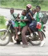 ??  ?? A commercial motorbike (Okada) rider with young passengers