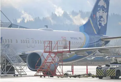  ?? PATRICK T. FALLON/AFP VIA GETTY IMAGES FILE ?? The Alaska Airlines 737 Max 9 that made an emergency landing in Portland, Oregon, on Jan. 5 is parked at a maintenanc­e hanger in Portland on Jan. 23, 2024. The missing emergency door is covered and taped.