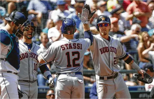  ?? Lindsey Wasson / Getty Images ?? Max Stassi is greeted by Yuli Gurriel (10) and Josh Reddick (22) after completing the Astros’ scoring with a three-run homer in Wednesday’s fifth inning.