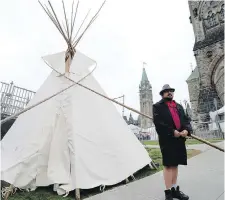  ?? JUSTIN TANG, CP ?? A man stands outside the protest teepee Thursday on a slope near the eastern entrance to Parliament Hill.