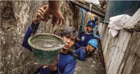  ?? | THE NEW YORK TIMES ?? Trabajador­es reparan una pared de mar que falló, inundando casas en una villa en Yakarta.