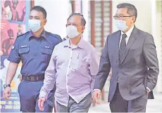  ??  ?? Mokhtar Haron (centre) arriving at the Sessions Court yesterday. - Bernama photo