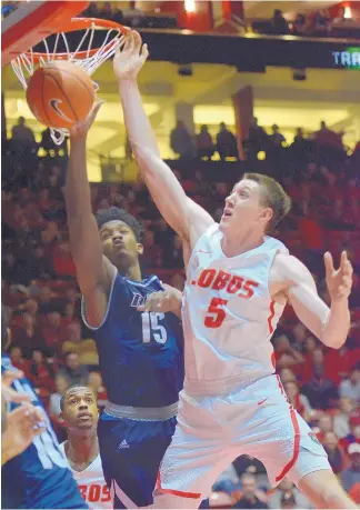  ?? GREG SORBER/JOURNAL ?? UNM senior Joe Furstinger (5) goes up against Rice’s Bishop Mency during Tuesday night’s game in the Pit. Furstinger, a senior, came off the bench and recorded his first double-double with 17 points and 12 rebounds to lead UNM to a 78-69 victory.