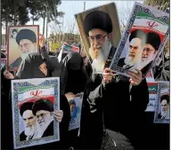  ??  ?? AP/MOHAMMAD ALI MARIZADIra­nian women hold posters of the late revolution­ary founder Ayatollah Ali Khomeini and Supreme Leader Ayatollah Ali Khamenei during a pro-government rally Wednesday in the holy city of Qom. Iranian authoritie­s were working to project a sense of stability in the country after a week of protests and deadly confrontat­ions.