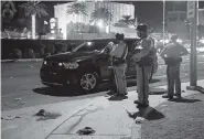  ?? THE ASSOCIATED PRESS ?? Police stand at the scene of a shooting along the Las Vegas Strip, the deadliest shooting in modern U.S. history, on Monday.