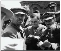  ?? The New York Times ?? An undated photo from the Yad Vashem Archive shows Nachman Blumental (center) taking notes in Chelmno, Poland, after the region was liberated from the Nazis.