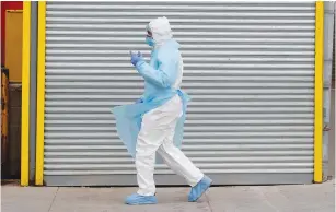  ?? (Brendan Mcdermid/Reuters) ?? A healthcare worker walks in Personal Protective Equipment (PPE) outside Wyckoff Heights Medical Center during the outbreak of the coronaviru­s disease in the Brooklyn borough of New York City yesterday.