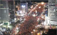  ?? KIM MIN-HEE/AFP ?? Protesters hold candles during a rally against South Korea’s President Park Geun-hye in central Seoul on Saturday.