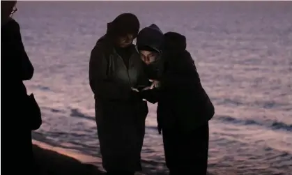  ?? ?? Palestinia­ns check the internet with their mobile phones in the central Gaza Strip, 15 December20­23. Photograph: Mohammed Saber/EPA