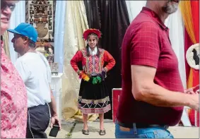  ?? SARAH GORDON/THE DAY ?? A crowd walks past Kaitlin Contveras, 16, of Norwich, as she wears the traditiona­l valicha costume during a Peruvian Fest on Sunday in downtown Norwich.