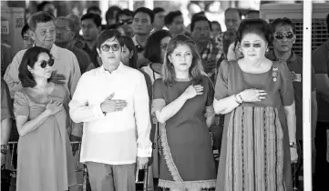  ??  ?? Ferdinand Marcos Jnr (second left), Imee (second right) and their mother, former Philippine first lady Imelda Marcos (right), listen to the national anthem during a wreath-laying ceremony at a monument to the late dictator during celebratio­ns to mark...
