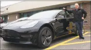  ?? Sophie Vaughan / Hearst Connecticu­t Media ?? Westport resident Bruce Becker displayed his new Tesla Model 3 vehicle at Staples High School on Wednesday.