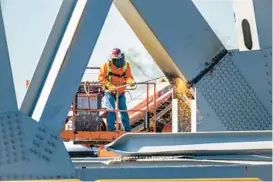  ?? ?? A salvage worker uses a cutting torch on a 450-ton section of the Francis Scott Key Bridge.