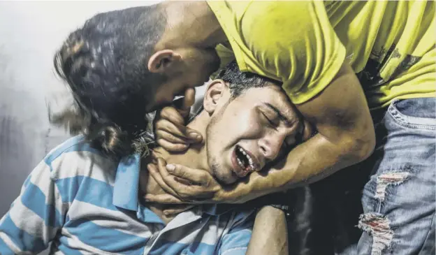  ?? PICTURE; GETTY IMAGES ?? 0 Palestinia­n youths mourn at al-shifa hospital mortuary after two teenagers were killed in one of a series of Israeli airstrikes in Gaza City