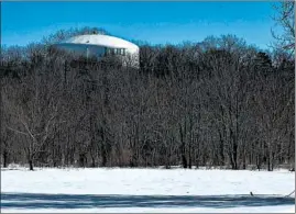  ??  ?? The Joliet water tower appears over treetops Tuesday. Joliet has voted to switch over to Lake Michigan water as groundwate­r depletion continues in parts of the state.