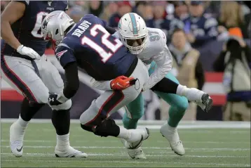  ?? CHARLES KRUPA — THE ASSOCIATED PRESS ?? Dolphins defensive end Trent Harris, right, sacks Patriots quarterbac­k Tom Brady in the second half on Sunday in Foxborough, Mass.