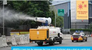  ??  ?? JAKARTA: A truck from the Indonesian Red Cross sprays disinfecta­nt along a street as a partial lockdown still exists amid concerns due to the COVID-19 coronaviru­s pandemic in Jakarta. — AFP