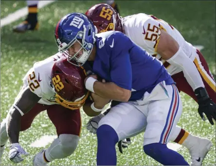  ?? JOHN MINCHILLO - THE ASSOCIATED PRESS ?? Washington Football Team’s Deshazor Everett (22) and Cole Holcomb (55) tackle New York Giants quarterbac­k Daniel Jones (8) during the second half of an NFL football game Sunday, Oct. 18, 2020, in East Rutherford, N.J.