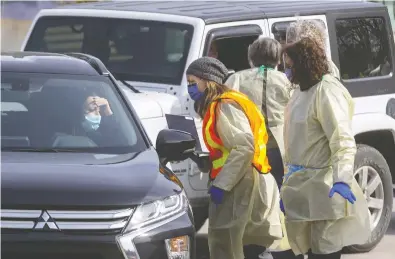  ?? MIKE HENSEN / POSTMEDIA NEWS ?? People are screened in their cars for COVID-19 at London’s first assessment centre at Oakridge Arena on March 16.
Their informatio­n was taken down and if necessary they were asked to park and go for further screening.