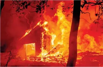  ?? AP PHOTO/NOAH BERGER ?? Flames from the Glass Fire consume a vineyard building in St. Helena, Calif., on Sunday.