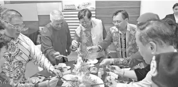  ??  ?? Abang Johari (centre), joined by Federation of Registered Chinese Associatio­n Bintulu president Hii Toh Him (second left), Tiong (left) and other guests, tosses the Yee Sang at Hii’s residence.