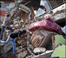  ?? ASSOCIATED PRESS ?? Residents inspect a building collapsed in Friday’s earthquake in Mamuju, West Sulawesi, Indonesia, Monday.