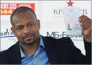  ?? Ivan Sekretarev / Associated Press ?? Former world boxing champion Roy Jones Jr. shows off his Russian passport during a news conference in Moscow in 2015. Jones and Mike Tyson, top, got permission from California’s athletic commission to return to the boxing ring next month because their fight would be strictly an exhibition.