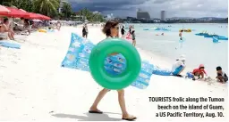  ??  ?? TOURISTS frolic along the Tumon beach on the island of Guam, a US Pacific Territory, Aug. 10.