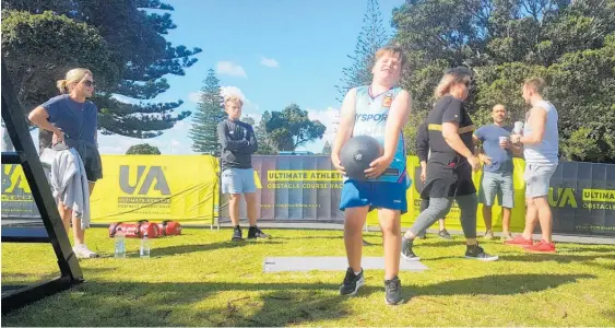  ?? Photo / Sandra Conchie ?? Aucklander Toni Jacka (far left) watches her son Max, 8, lift a 20kg dumbbell at the Ultimate Athlete Demo Day at Mount Drury.