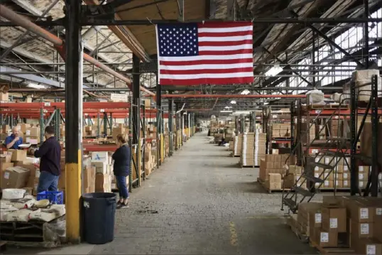  ?? Luke Sharrett/Bloomberg ?? A U.S. flag in a warehouse at the Fiesta Tableware Co. factory in Newell, West Va., in 2021. Economists are trying to figure out where workers that would fill jobs like these and others have gone.