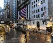  ?? STEPHANIE KEITH / THE NEW YORK TIMES ?? A pedestrian walks along Wall Street by the New York Stock Exchange on Monday morning. The S&P 500 fell as much as 3% in early trading, even after the Fed unveiled its new bond-buying program.
