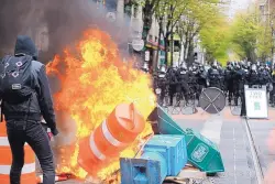  ?? DAVE KILLEN/THE OREGONIAN ?? Police try to disperse people participat­ing in a May Day rally in downtown Portland, Ore., on Monday. They said the permit obtained for the event was canceled as some marchers began throwing projectile­s at officers.