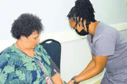  ?? CONTRIBUTE­D ?? Vice-President of the Shipping Associatio­n of Jamaica, Corah Ann Robertson Sylvester (left), gets her blood pressure checked by Newport Medical Group’s Nurse Burke during the body’s compliment­ary screening on World Hypertensi­on Day.