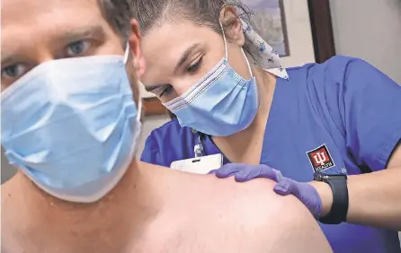  ?? KELLY WILKINSON/ USA TODAY NETWORK ?? Physical therapist Katherine Morin works with patient Adam Bodony at IU Health North Hospital in in Carmel, Ind. Bodony developed persistent symptoms after a bout with COVID- 19 in 2020.