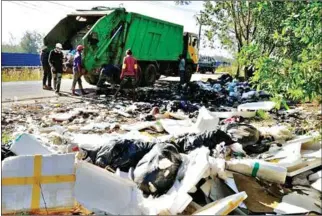  ?? SUPPLIED ?? Sanitation workers clear a large pile of trash in Preah Sihanouk province, where residents have accused a new waste management company of shirking its duties.