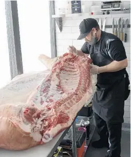  ?? MICHAEL LAUGHLIN/SUN SENTINEL PHOTOS ?? The Butcher and The Bar butcher-partner Jason Brown works on a 315-pound pig on Sept. 11. Dinner and dine-in service will begin next week.