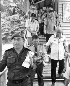  ??  ?? Manyin (right) and his delegates leave the school hostel immediatel­y after the near structural collapse at the walkway.