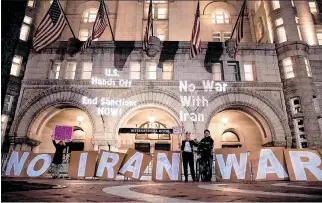  ?? MICHAEL REYNOLDS / EFE ?? Washington. Activistas proyectan el mensaje “No a la guerra con Irán” en el edificio del Trump Internatio­nal Hotel.