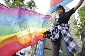  ??  ?? TAIPAI: This picture taken on November 17, 2016 shows a supporter of same-sex marriage holding a rainbow flag outside the Parliament. — AFP