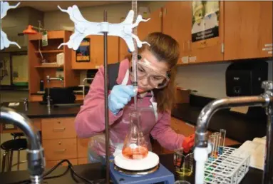  ?? BRIANA CONTRERAS — THE MORNING JOURNAL ?? Brookside High School junior Nicole Londo works at an experiment in the high school’s chemistry lab, located at the district’s newer building, 1662 Harris Road in Sheffield Lake. Equipment and classroom supplies like a beaker and textbook, as pictured...