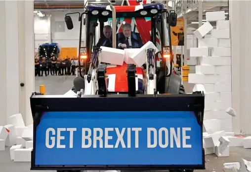  ??  ?? Bulldozer. En visite dans une entreprise de constructi­on du Staffordsh­ire, le 10 décembre, Boris Johnson, au volant d’une pelleteuse aux couleurs de l’Union Jack et ornée de son slogan de campagne « Faire le Brexit », pulvérise un mur de briques en polystyrèn­e sur lequel était inscrit le mot « impasse ».