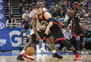  ?? WILLIE J. ALLEN JR., THE ASSOCIATED PRESS ?? Raptors Jonas Valanciuna­s and Orlando’s Bismack Biyombo battle in Orlando, Fla., Friday. Orlando won 102-94.