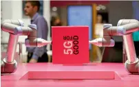  ?? — Bloomberg ?? robotic arms lift a box on the deutsche Telekom stand. 5g is expected to enable lightning-quick downloads.