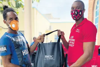  ??  ?? Oneil Green (left), collects his care package from Khaleel Smith, brand manager at BCIC.